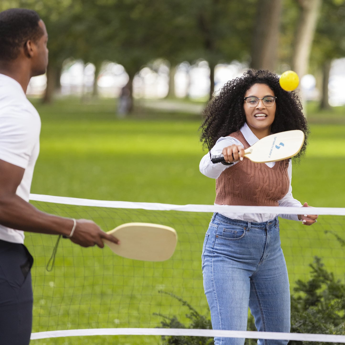 Sportcraft PickleBall Set - Lifestyle Image - People playing PickleBall outside in park