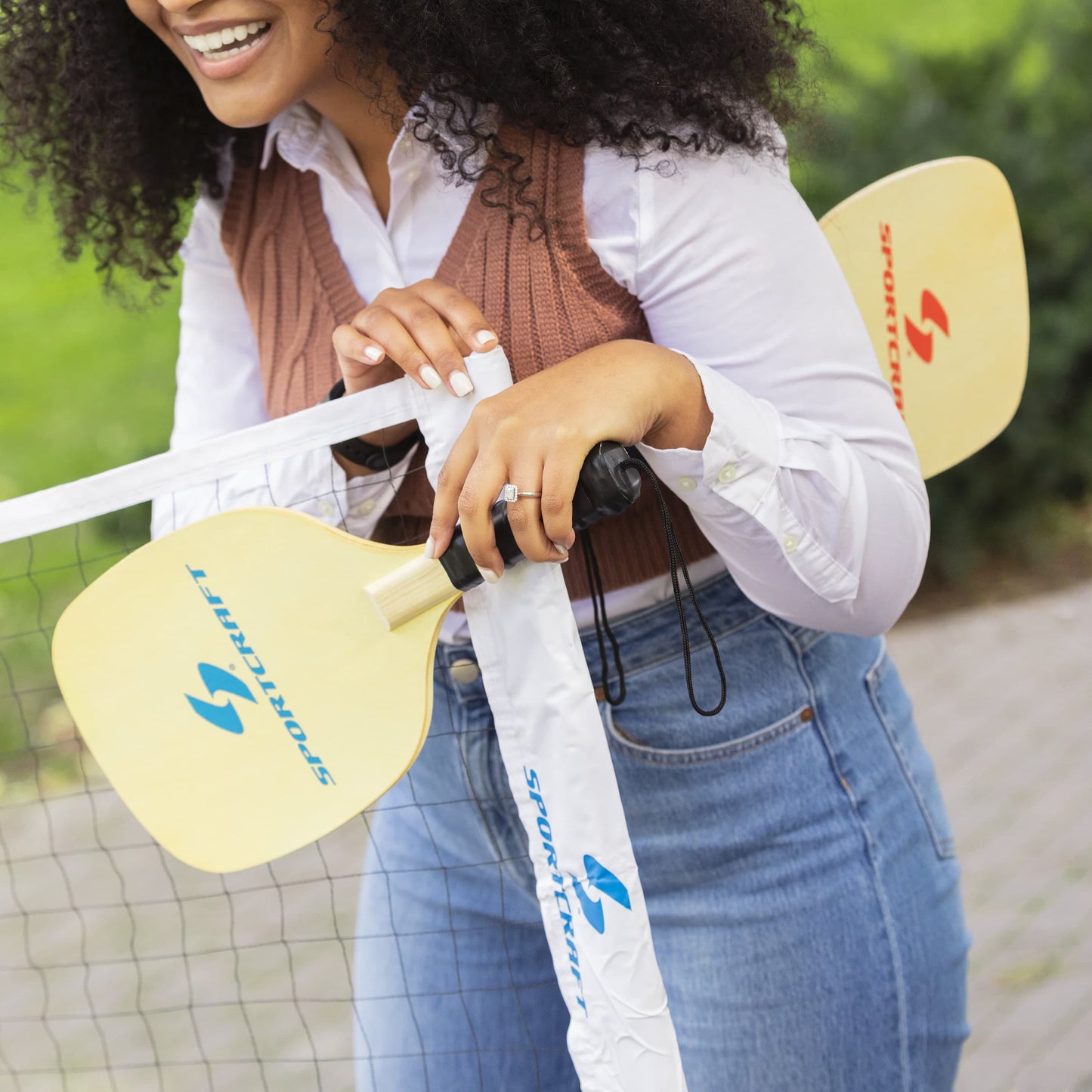 Sportcraft PickleBall Set - Lifestyle Image - Woman hold PickleBall paddles beside net