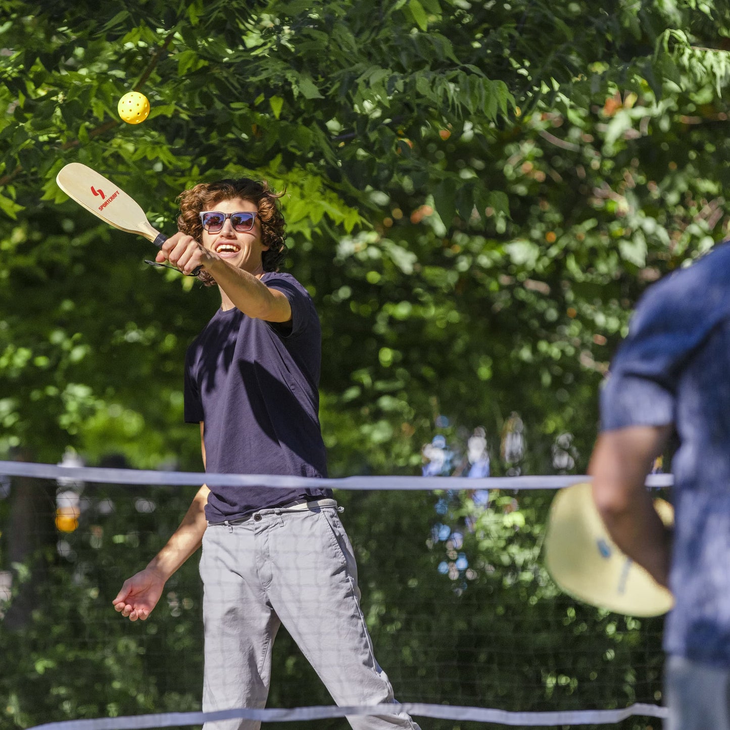 Sportcraft PickleBall Set - Lifestyle Image - People playing PickleBall outside in park