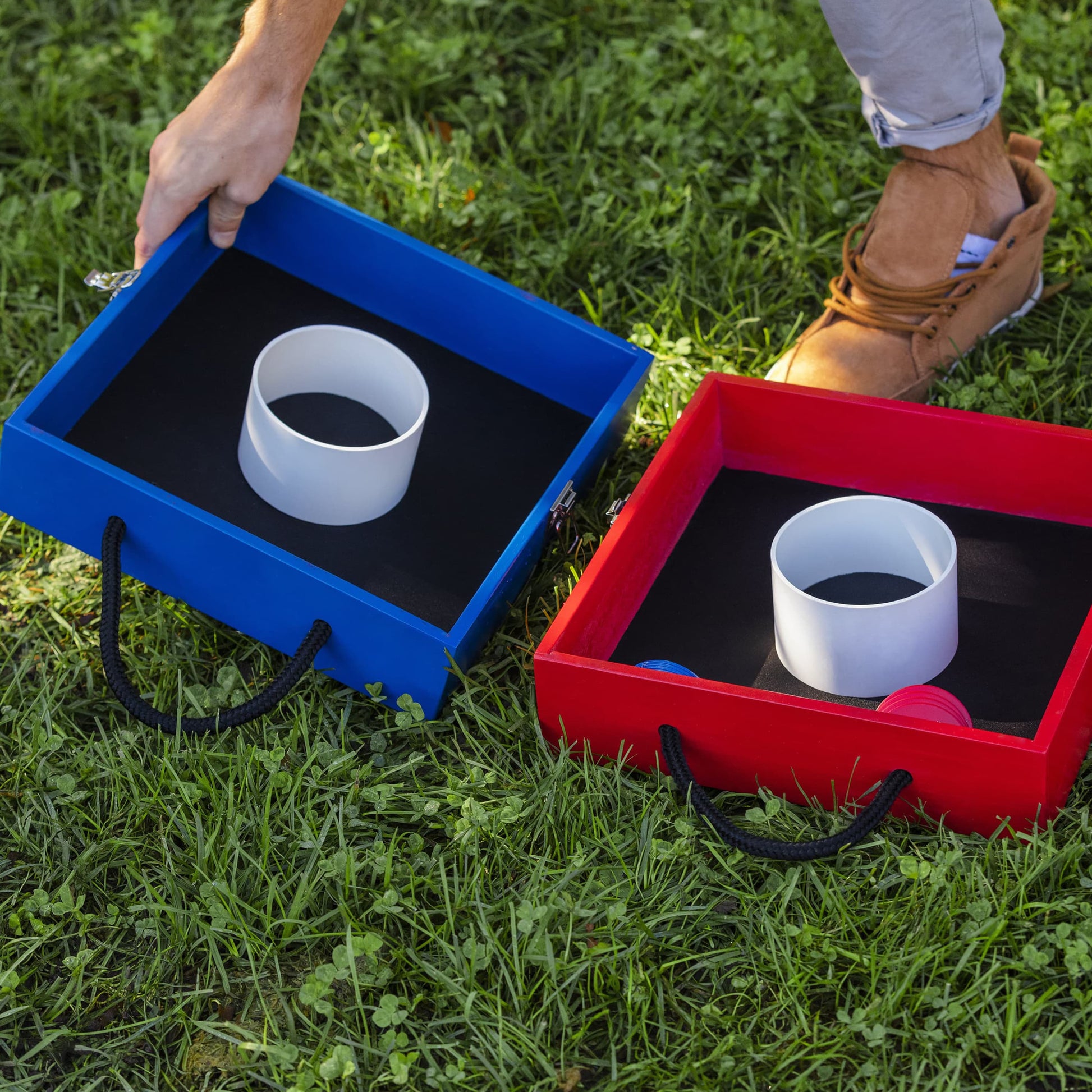 Sportcraft Wooden Washer Toss Game - Lifestyle Image - Showing both Blue & Red Product Parts sitting on grass