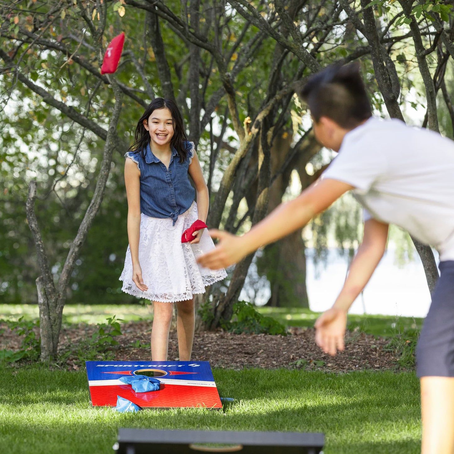Sportcraft Wooden Corn Hole Bean Bag Toss Lifestyle Image, Kids playing game in a park
