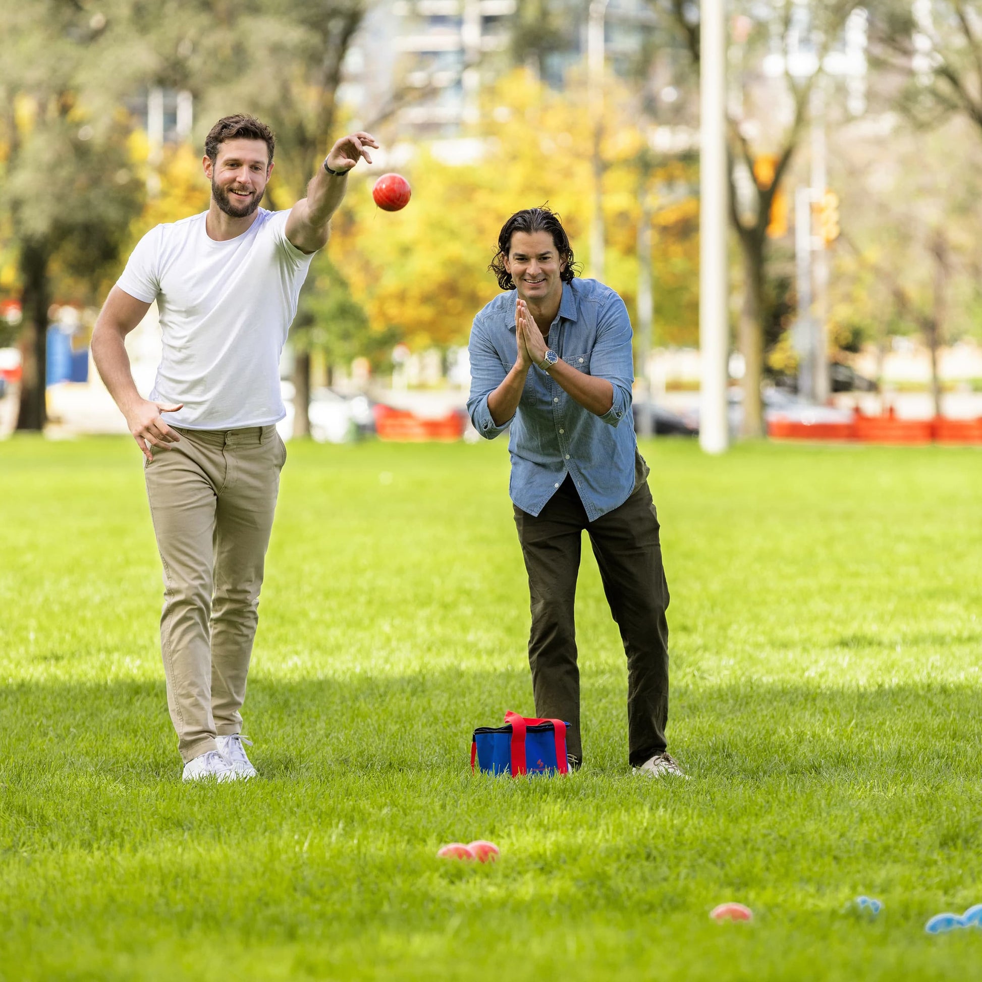 Sportcraft Bocce Ball Set Lifestyle Image, two men playing Bocce Ball in a park, one throwing ball
